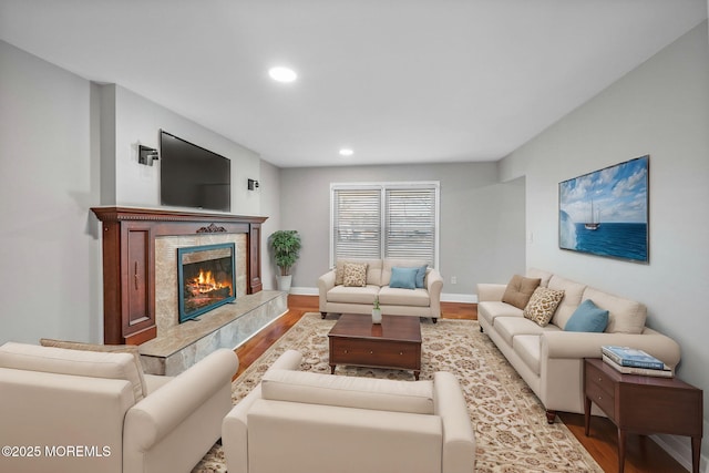 living room featuring a tile fireplace and light wood-type flooring