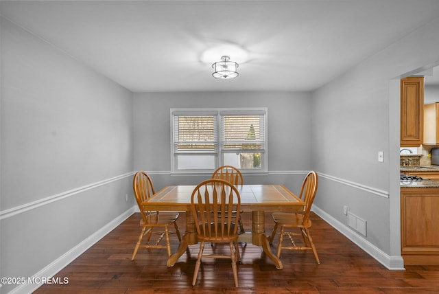 dining room featuring sink and dark wood-type flooring