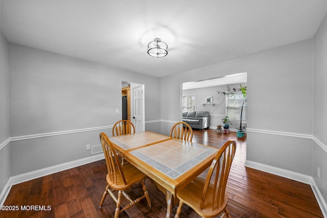 dining space with dark hardwood / wood-style flooring