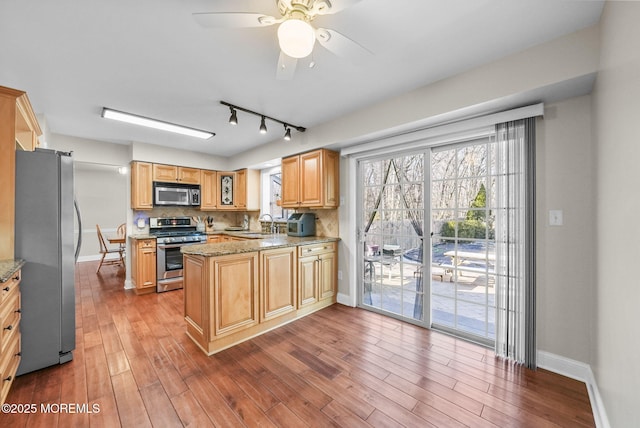 kitchen featuring light hardwood / wood-style flooring, ceiling fan, light stone countertops, tasteful backsplash, and stainless steel appliances