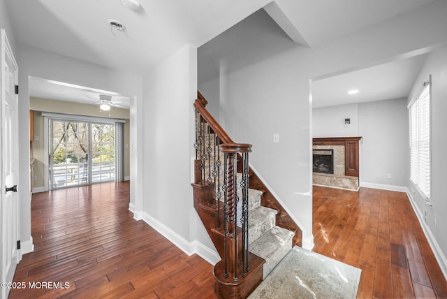 stairway with wood-type flooring and ceiling fan