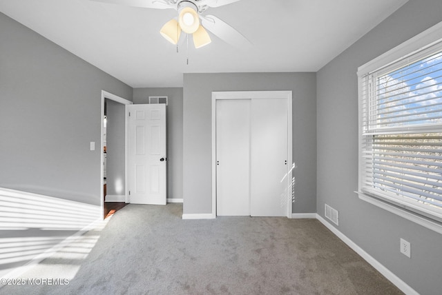 unfurnished bedroom featuring carpet flooring, a closet, and ceiling fan