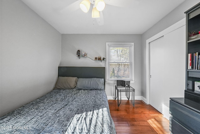 bedroom with ceiling fan, dark hardwood / wood-style floors, and a closet