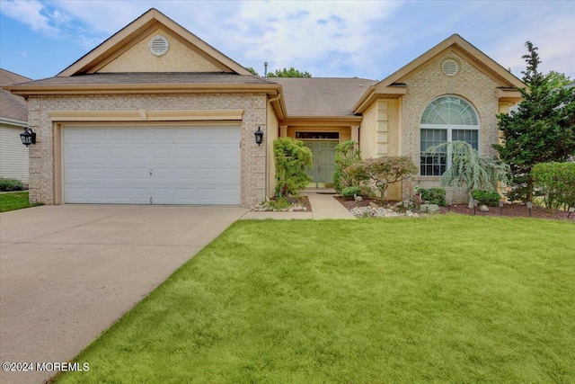 view of front of property with a front yard and a garage