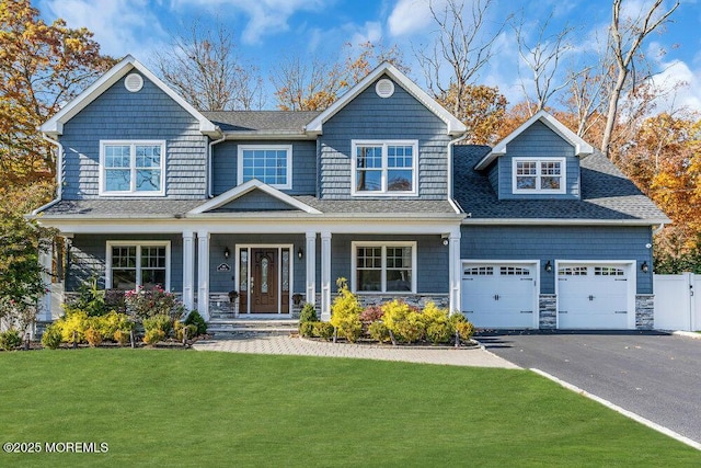 craftsman-style house featuring a porch, a garage, and a front yard