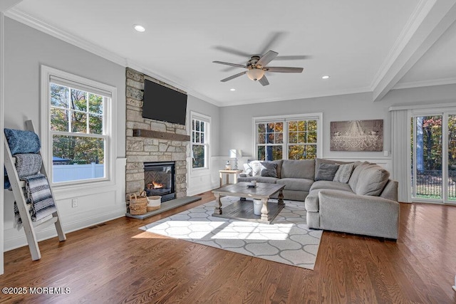 living room with crown molding, a fireplace, ceiling fan, and wood-type flooring