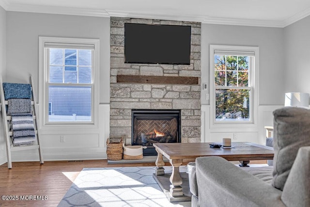 living room with a fireplace, hardwood / wood-style flooring, and ornamental molding