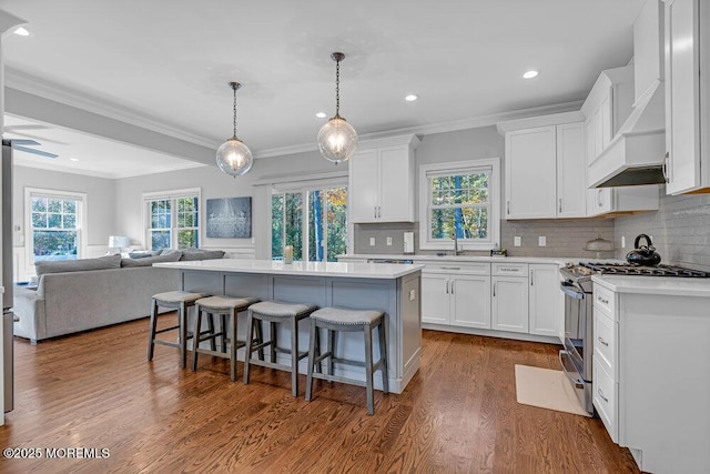 kitchen featuring a center island, white cabinetry, backsplash, and stainless steel gas range