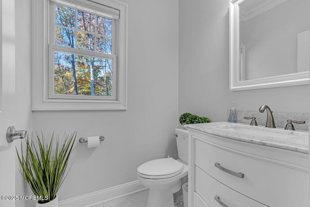 bathroom with vanity, toilet, and ornamental molding