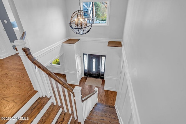 entryway with hardwood / wood-style floors, plenty of natural light, and a chandelier