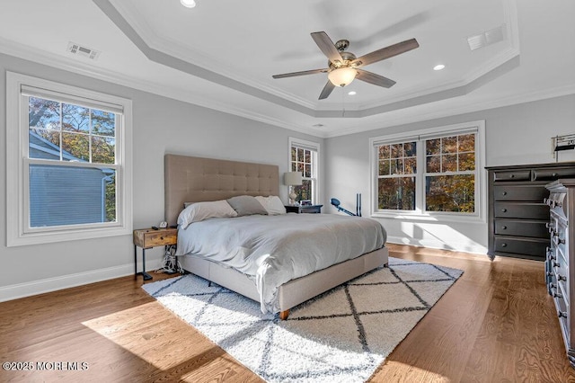 bedroom with ceiling fan, crown molding, and a tray ceiling