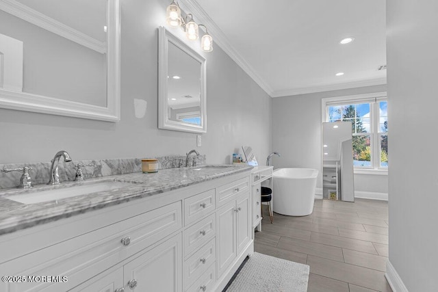 bathroom with a bathing tub, vanity, ornamental molding, and tile patterned flooring