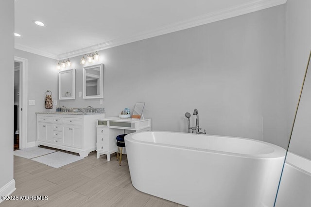 bathroom featuring vanity, a bathtub, and crown molding