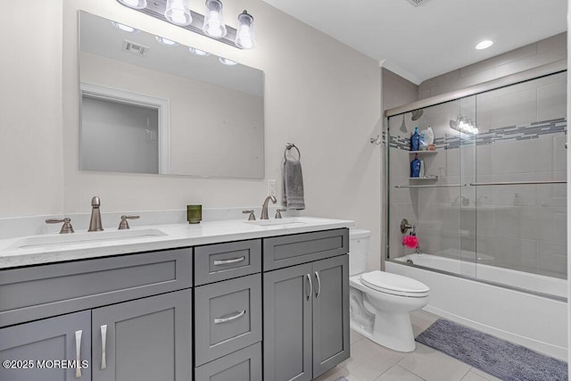 full bathroom featuring tile patterned floors, vanity, toilet, and bath / shower combo with glass door