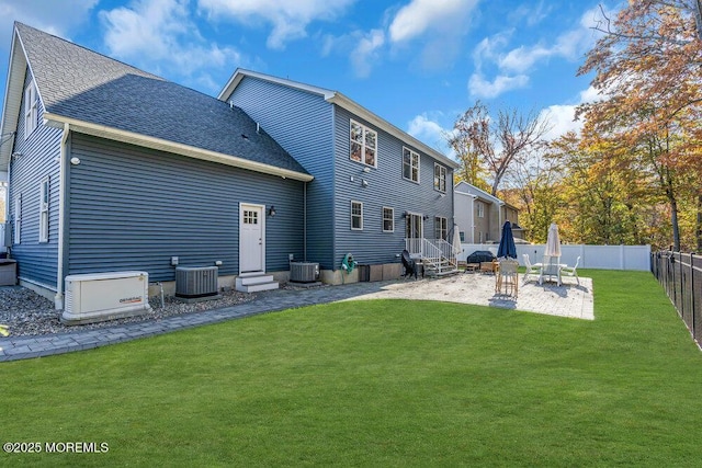 back of property featuring a lawn, central AC, and a patio