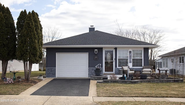 view of front facade featuring cooling unit, a garage, and a front lawn