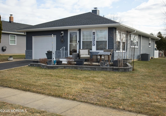 view of front facade with central AC unit, a garage, and a front lawn