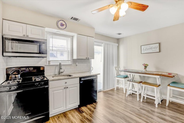 kitchen with white cabinetry, sink, ceiling fan, light hardwood / wood-style flooring, and black appliances