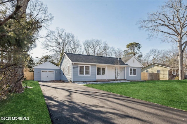 ranch-style home featuring a garage, an outdoor structure, and a front lawn