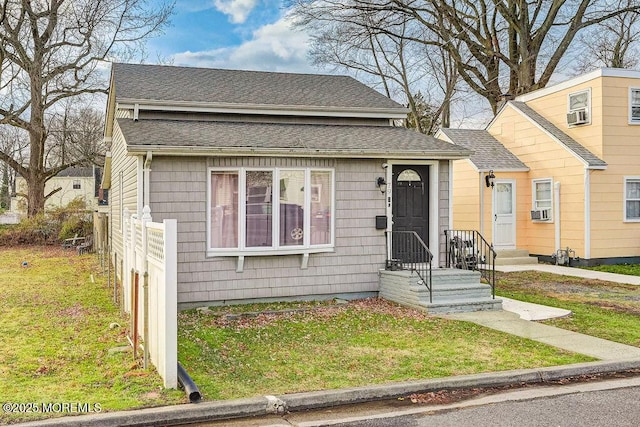 bungalow with a front lawn and cooling unit