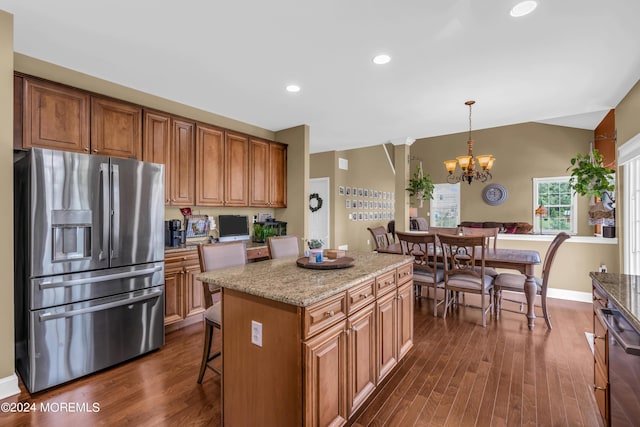 kitchen with appliances with stainless steel finishes, dark wood-type flooring, a chandelier, a center island, and hanging light fixtures