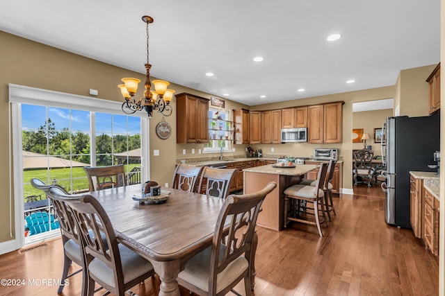 dining space featuring sink, a chandelier, and dark hardwood / wood-style floors