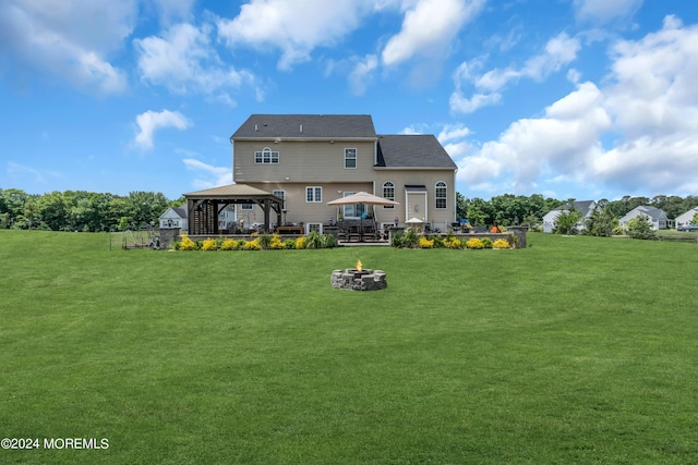 back of house with a gazebo, an outdoor fire pit, and a lawn