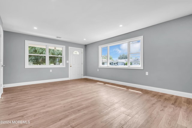 unfurnished room featuring a healthy amount of sunlight and light hardwood / wood-style floors