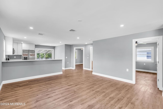 unfurnished living room featuring ceiling fan and light hardwood / wood-style flooring