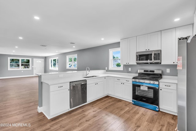 kitchen with light hardwood / wood-style floors, sink, stainless steel appliances, and white cabinetry