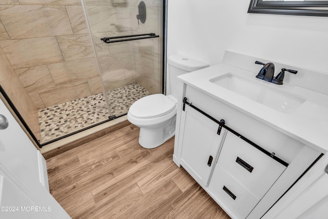 bathroom featuring toilet, vanity, walk in shower, and hardwood / wood-style flooring