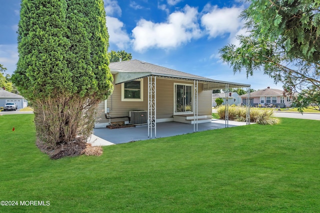 rear view of house with a lawn, central AC unit, and a patio area