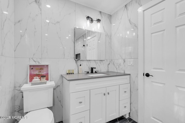 bathroom featuring vanity, tile walls, crown molding, and toilet