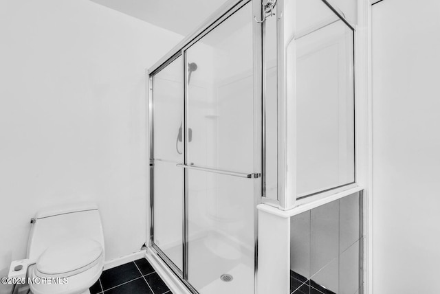 bathroom featuring tile patterned flooring, toilet, and walk in shower