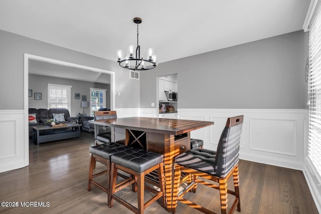 dining space featuring dark hardwood / wood-style flooring and a chandelier