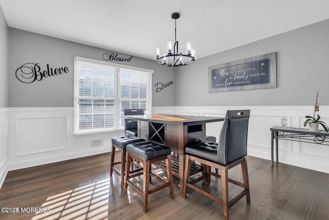 dining space with an inviting chandelier and dark hardwood / wood-style flooring