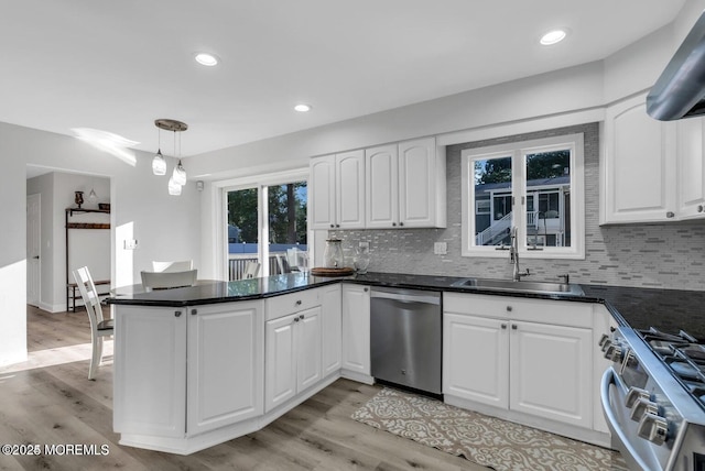 kitchen with sink, white cabinetry, light hardwood / wood-style flooring, appliances with stainless steel finishes, and pendant lighting