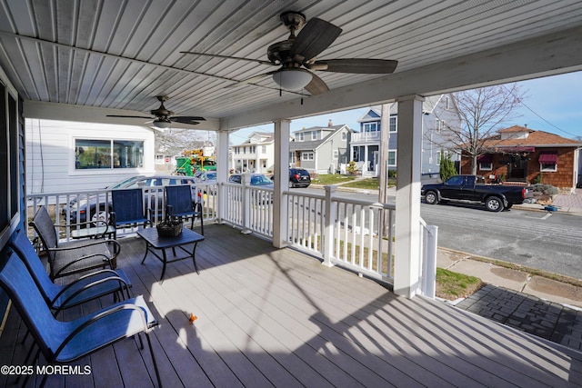 wooden deck featuring a porch and ceiling fan