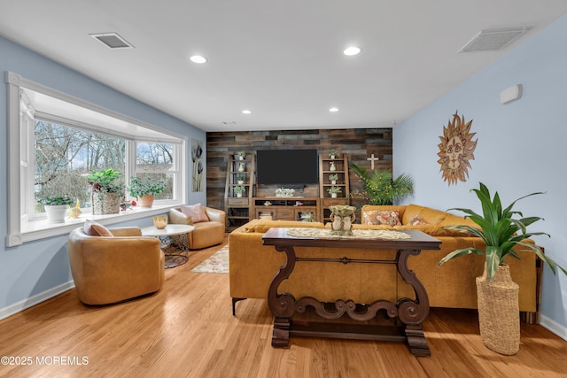 living room featuring wood walls and light hardwood / wood-style flooring