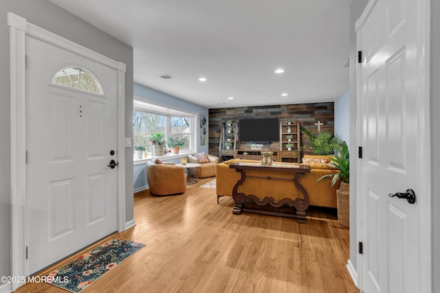 entrance foyer with wooden walls and hardwood / wood-style flooring