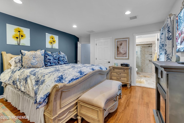 bedroom featuring ensuite bathroom and light hardwood / wood-style floors