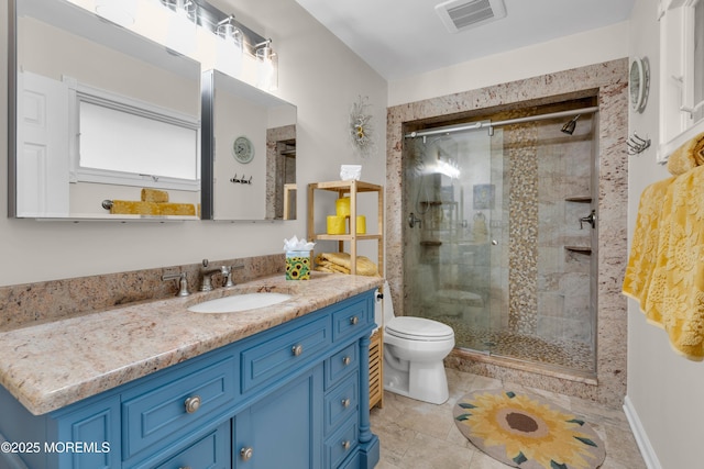 bathroom featuring toilet, vanity, tile patterned flooring, and a shower with shower door