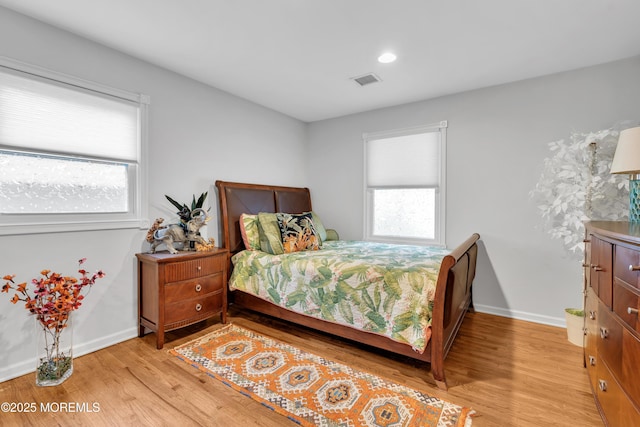 bedroom with light hardwood / wood-style flooring and multiple windows