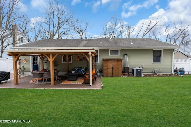 back of property with a yard, central AC, a patio, and an outdoor living space