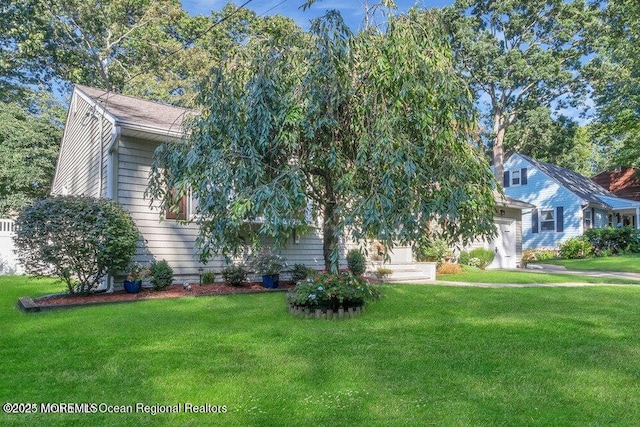 view of property hidden behind natural elements featuring a front yard