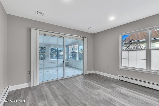 spare room with light hardwood / wood-style flooring and a baseboard heating unit