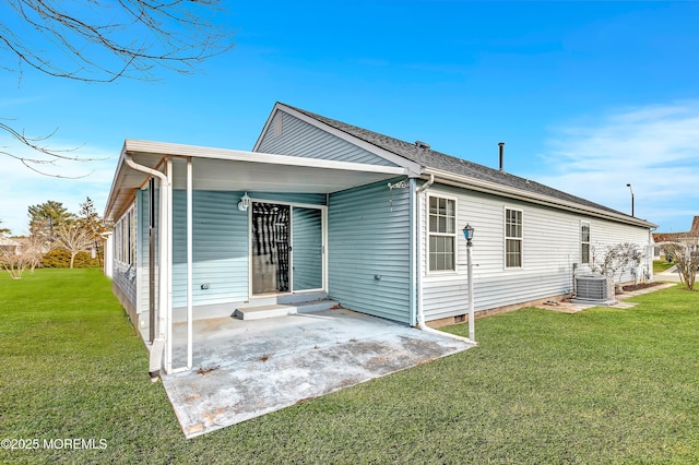 back of property with central AC, a yard, and a patio