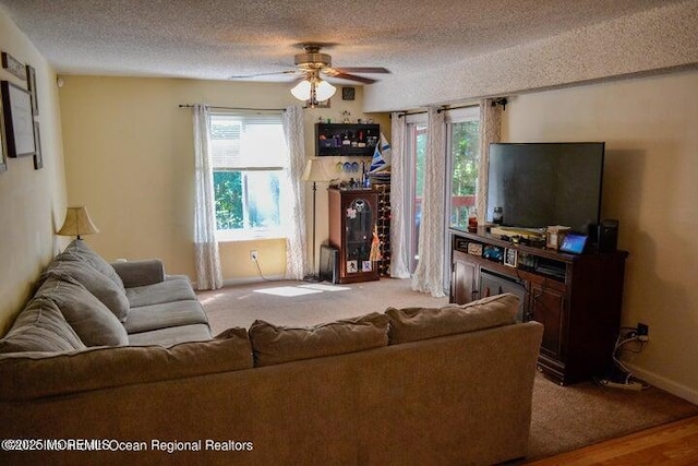 living room featuring ceiling fan and a textured ceiling