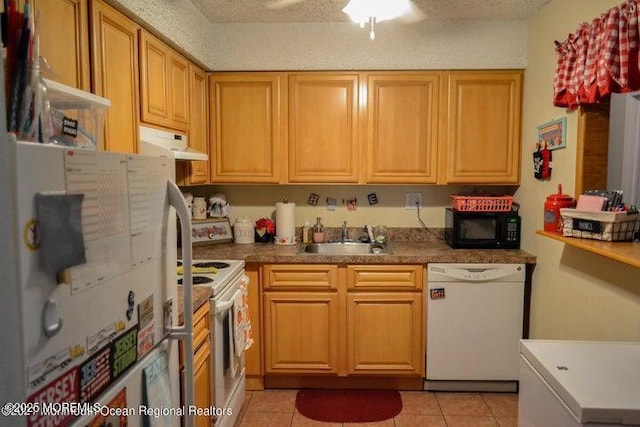 kitchen with a textured ceiling, white appliances, sink, and light tile patterned floors