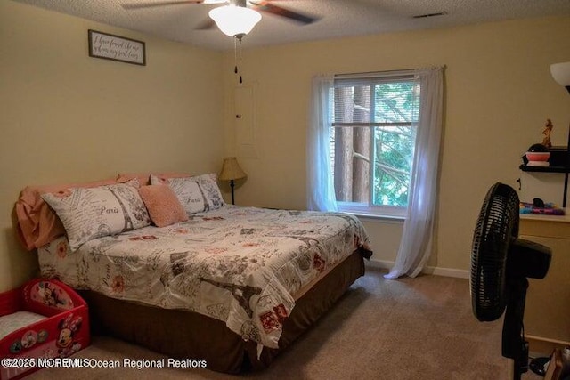 carpeted bedroom with ceiling fan and a textured ceiling